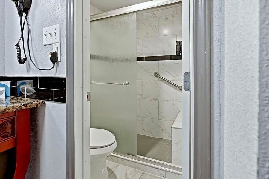 Guest bathroom with a glass-door walk-in shower and granite vanity