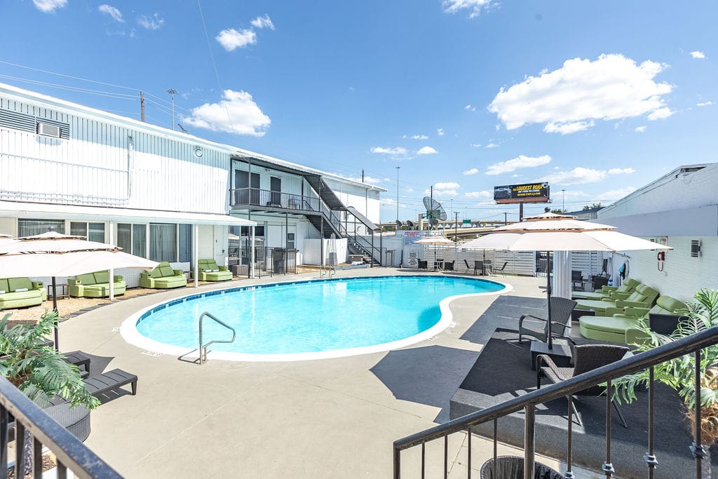 Seasonal outdoor pool courtyard with umbrellas, loungers, and cabana seating