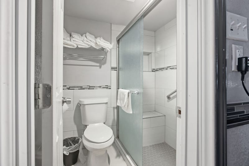 Renovated bathroom with glass-door walk-in shower and built-in bench