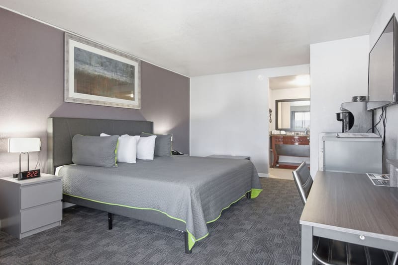 Standard King Room at R Nite Star Hotel & Lounge with a king bed, gray quilted bedspread, desk, and flat-screen TV