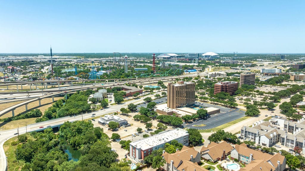 Aerial view toward Arlington's Entertainment District with Six Flags Over Texas, Globe Life Field, and AT&T Stadium on the horizon