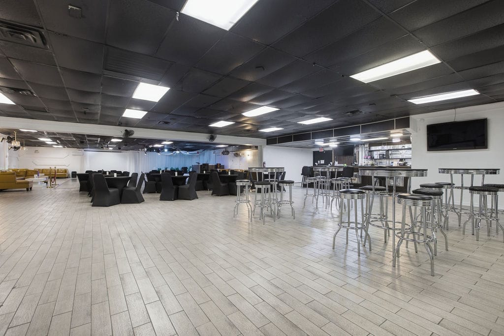 Event hall arranged with cocktail tables, bar stools, and lounge seating