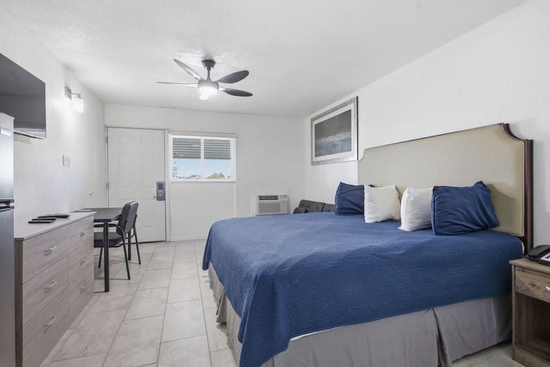 Mini Kitchen Room with a king bed, ceiling fan, dining table, and dresser