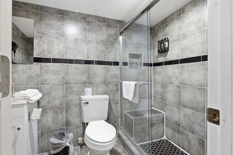 Renovated bathroom with a glass-door shower and corner vanity